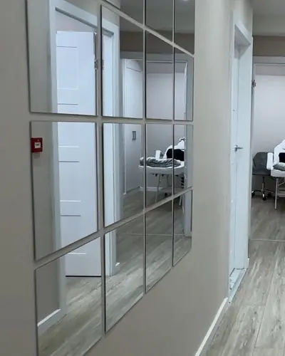 Bright hallway to the private treatment rooms, with a panelled mirror wall and gold leaf artwork