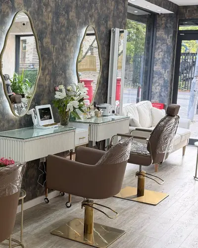 Salon floor with backlit organic mirrors, blush chairs and a wall of gel polish