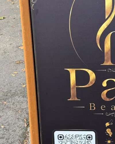 Pari Beauty pavement sign with the gold PB monogram on charcoal